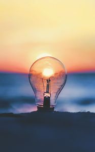 Preview wallpaper light bulb, sunset, sun, focus