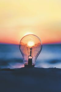 Preview wallpaper light bulb, sunset, sun, focus