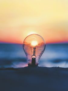 Preview wallpaper light bulb, sunset, sun, focus