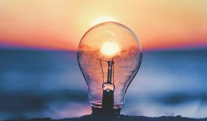 Preview wallpaper light bulb, sunset, sun, focus