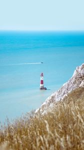 Preview wallpaper lighthouse, building, boat, sea, grass, horizon