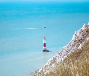 Preview wallpaper lighthouse, building, boat, sea, grass, horizon