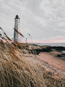Preview wallpaper lighthouse, building, grass, coast, sea