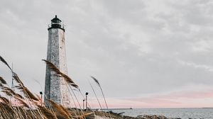 Preview wallpaper lighthouse, building, grass, coast, sea