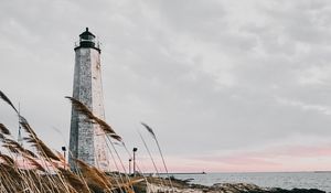 Preview wallpaper lighthouse, building, grass, coast, sea
