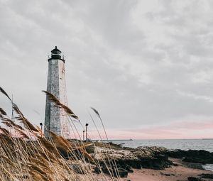 Preview wallpaper lighthouse, building, grass, coast, sea