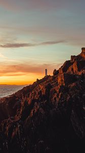 Preview wallpaper lighthouse, building, rocks, slope, sky