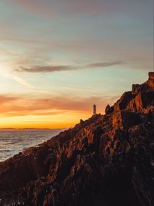 Preview wallpaper lighthouse, building, rocks, slope, sky