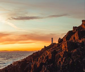 Preview wallpaper lighthouse, building, rocks, slope, sky