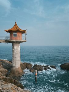 Preview wallpaper lighthouse, building, sea, coast, rocks, water
