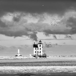 Preview wallpaper lighthouse, building, shore, sea, birds, sky, black and white