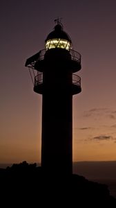 Preview wallpaper lighthouse, building, silhouette, sunset, coast