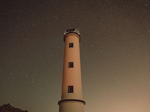 Preview wallpaper lighthouse, building, starry sky, stars, night, rocks