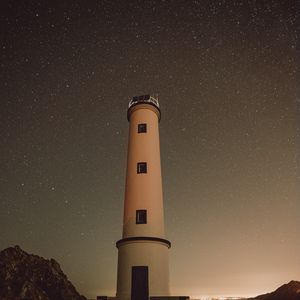 Preview wallpaper lighthouse, building, starry sky, stars, night, rocks