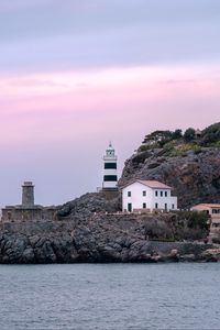 Preview wallpaper lighthouse, buildings, rock, sea