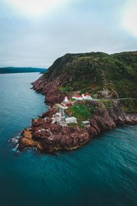 Preview wallpaper lighthouse, buildings, rocks, sea, slope