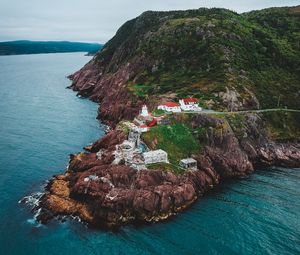 Preview wallpaper lighthouse, buildings, rocks, sea, slope