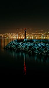Preview wallpaper lighthouse, city, water, night, stones
