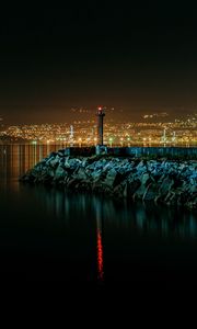 Preview wallpaper lighthouse, city, water, night, stones