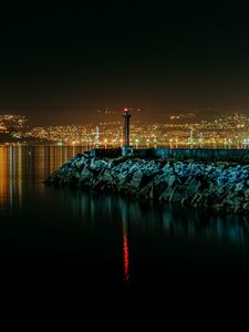 Preview wallpaper lighthouse, city, water, night, stones
