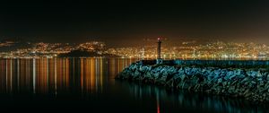 Preview wallpaper lighthouse, city, water, night, stones