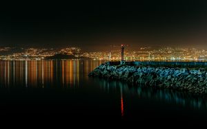 Preview wallpaper lighthouse, city, water, night, stones