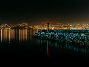 Preview wallpaper lighthouse, city, water, night, stones
