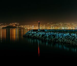 Preview wallpaper lighthouse, city, water, night, stones