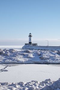 Preview wallpaper lighthouse, coast, snow, water, winter, nature