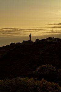 Preview wallpaper lighthouse, hills, silhouettes, evening