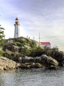 Preview wallpaper lighthouse, house, stones, shore, sea