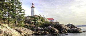 Preview wallpaper lighthouse, house, stones, shore, sea