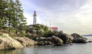 Preview wallpaper lighthouse, house, stones, shore, sea