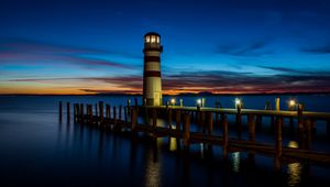 Preview wallpaper lighthouse, pier, sea, lights, twilight