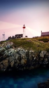 Preview wallpaper lighthouse, rock, cliff, sea, rays