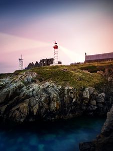 Preview wallpaper lighthouse, rock, cliff, sea, rays