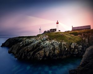 Preview wallpaper lighthouse, rock, cliff, sea, rays