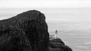 Preview wallpaper lighthouse, rock, cliff, sea, black and white