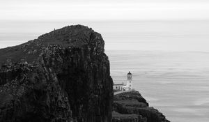 Preview wallpaper lighthouse, rock, cliff, sea, black and white