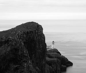 Preview wallpaper lighthouse, rock, cliff, sea, black and white