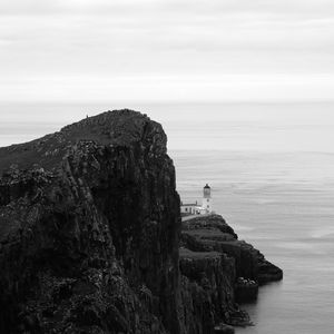 Preview wallpaper lighthouse, rock, cliff, sea, black and white