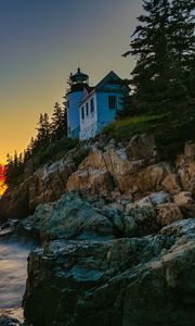 Preview wallpaper lighthouse, rocks, cliff, sea, sunset
