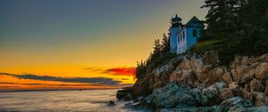 Preview wallpaper lighthouse, rocks, cliff, sea, sunset