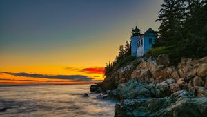 Preview wallpaper lighthouse, rocks, cliff, sea, sunset