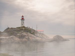 Preview wallpaper lighthouse, rocks, fog, coast, water