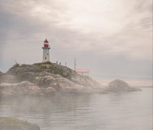 Preview wallpaper lighthouse, rocks, fog, coast, water