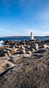 Preview wallpaper lighthouse, rocks, stones, sea, clouds, nature