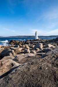Preview wallpaper lighthouse, rocks, stones, sea, clouds, nature