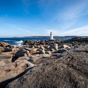 Preview wallpaper lighthouse, rocks, stones, sea, clouds, nature