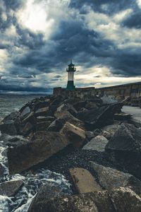 Preview wallpaper lighthouse, sea, coast, stones, clouds
